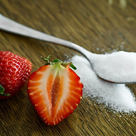 Two berries and a spoon full of sugars