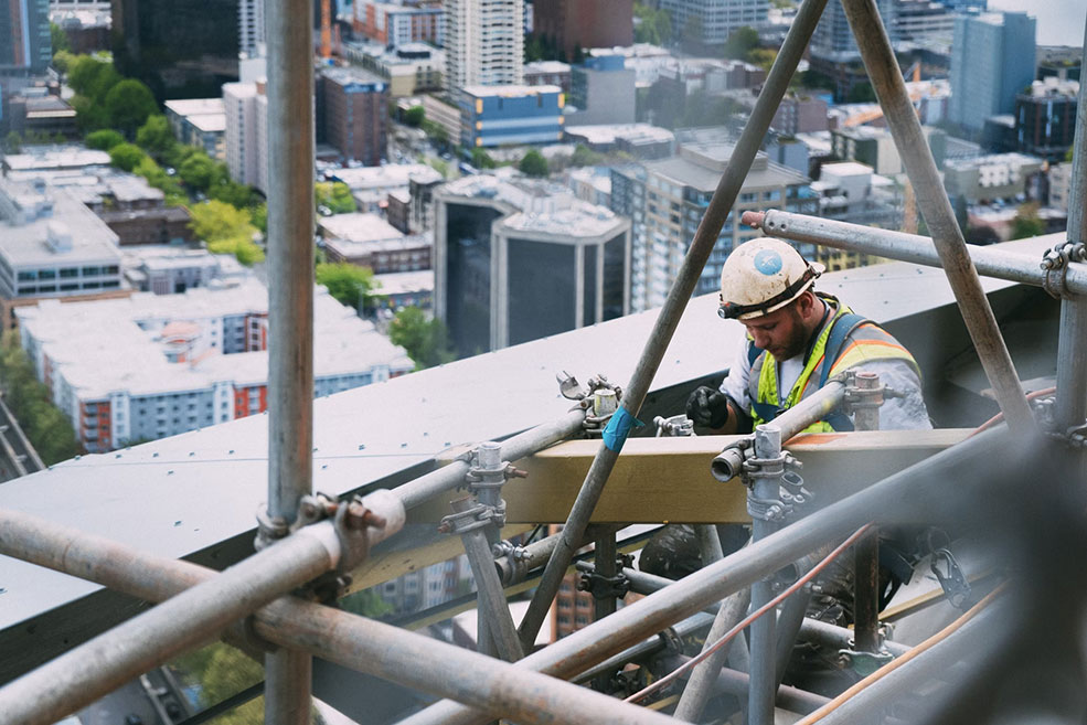 Trois piles de pièces en or de taille croissante avec une main ajoutant une pièce à la troisième pile.