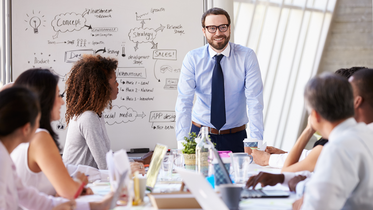 Caucasian Businessman Leading Meeting At Boardroom Table